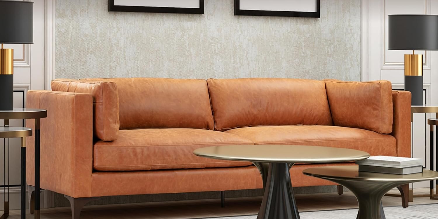Poly & Bark Argan cognac leather sofa with bolster pillows between two black and brass table lamps