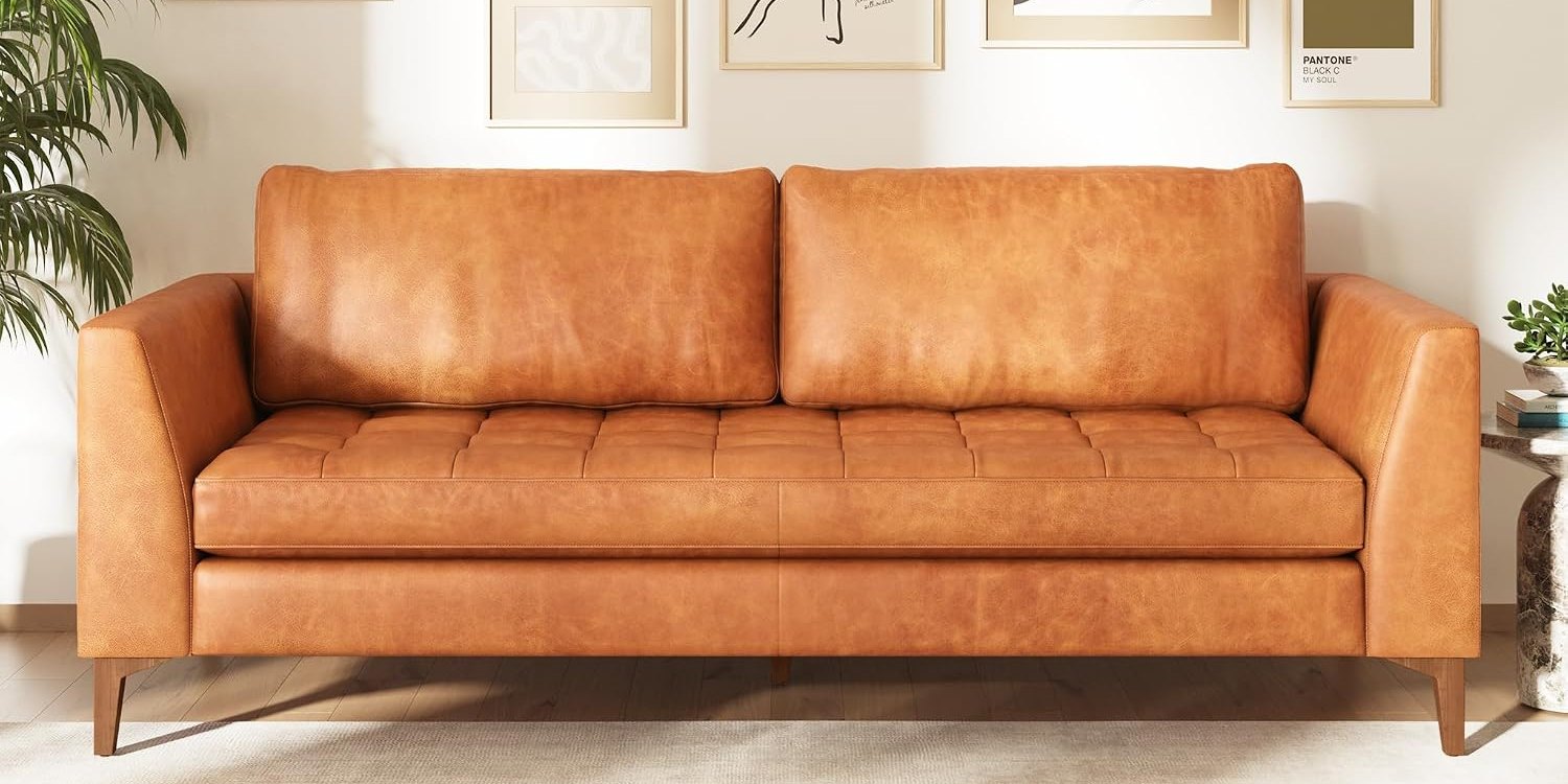 Poly & Bark Calle cognac leather sofa beneath a gallery wall of framed prints